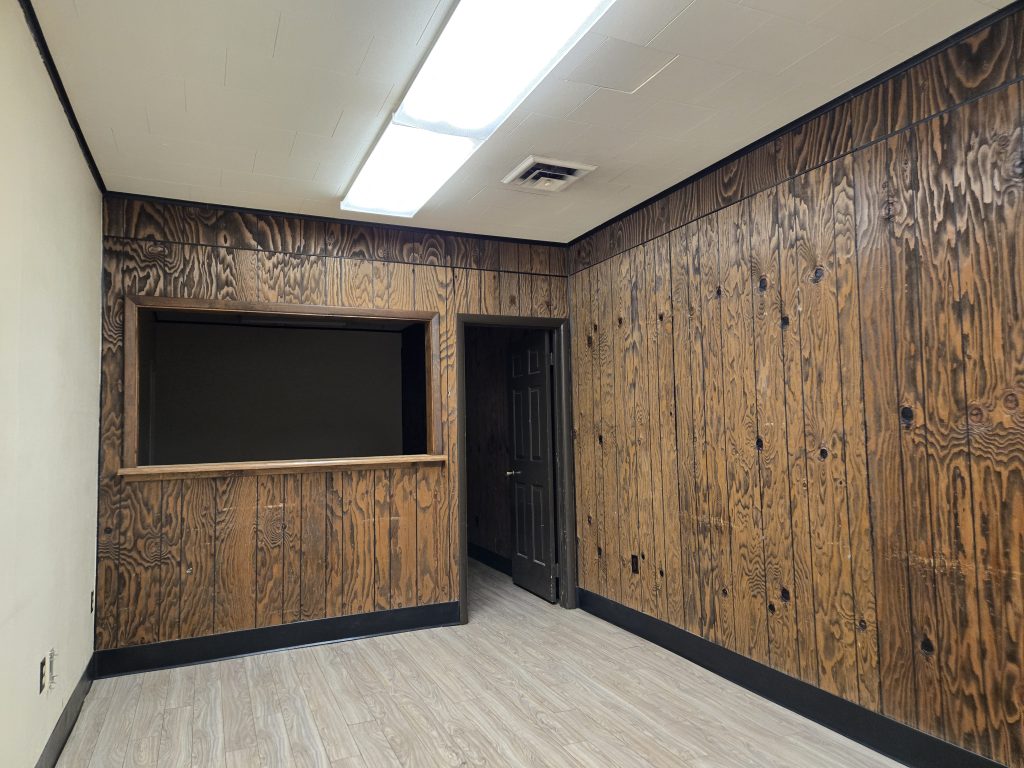 EVillage interior room with wood paneling and bright ceiling lights